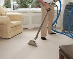 Carpet cleaning professional removing dirt and stains with a hot-water extraction tool in a home, Eugene, OR.